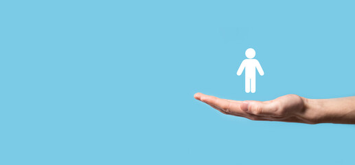 Obraz premium Male hand holding human icon on blue background. Human Resources HR management Recruitment Employment Headhunting Concept.Select team leader concept. Male hand click on man icon.Banner ,copy spase.