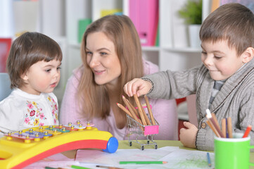 Fototapeta premium Mother with children playing together at home