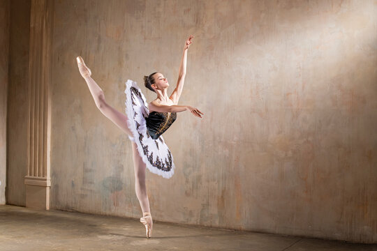 Young Ballerina In White Tutu Dancing In A Spotlight In Vintage Scene