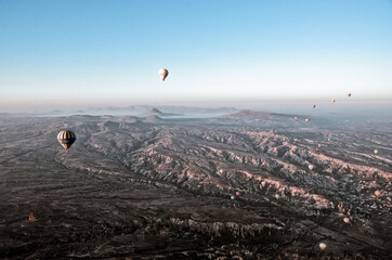 TURKEY, CAPPADOCIA, GOREME:  Aerial scenic view of hot air balloons flying over valleys of Göreme National Park