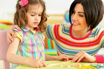 Cute little girl with her mother studying