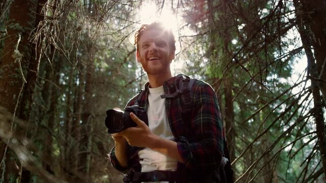 Man taking photos of landscape on camera. Traveler using photo camera in forest