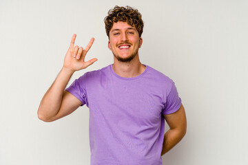 Fototapeta premium Young caucasian man isolated on white background showing rock gesture with fingers