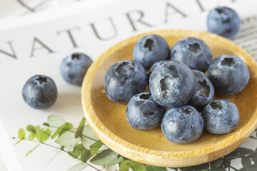 Blueberries in a wooden plate and the inscription natural