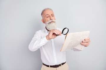 Photo of handsome strict grey hair old man teacher read magazine wear white shirt isolated on grey...