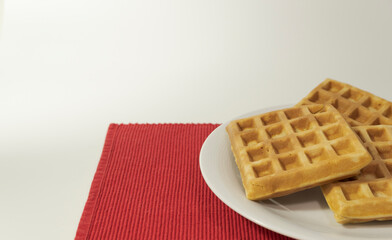 Obraz na płótnie Canvas waffles served for breakfast, top view. on a white-red background.