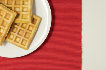 Obraz na płótnie Canvas waffles served for breakfast, top view. on a white-red background