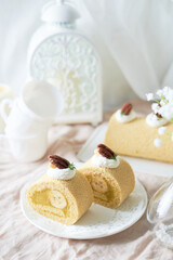 Banana Swiss Roll Cake with banana cream filling set on white cafe table.