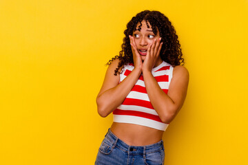 Young mixed race woman isolated on yellow background scared and afraid.