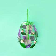 Spring flowers with tea in a drinking bottle with a tube. Creative idea in a jar. Pastel soft colors.