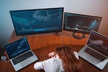 tired female beginner trader sleeping near monitor with stock chart at workplace
