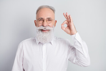 Photo of happy cheerful old man smile good mood show okay sing wear glasses isolated on grey color background