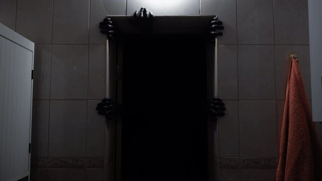 A demon from the darkness grabs the doorway with its hands. Deno from hell.