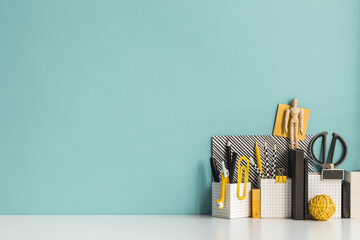 Creative desk with a blank picture frame, desk objects, drawing supplies, pencils, brushes, near...