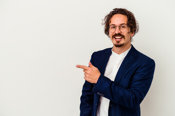 Young business man isolated on white background smiling and pointing aside, showing something at blank space.