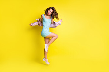 Fototapeta na wymiar Full length profile photo of pretty person jumping have fun toothy smile isolated on yellow color background