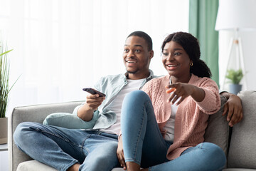 Obraz premium Happy african american family watching TV together at home