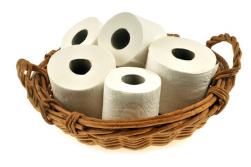 Rouleaux de papier toilette dans une corbeille en osier en gros plan sur fond blanc