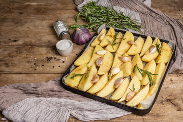 Spiced pieces of raw potato prepared to bake on old table