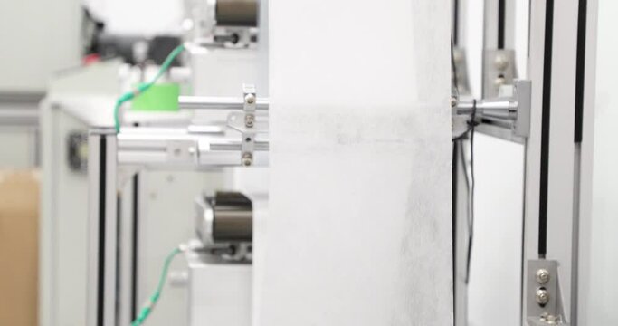 Face Mask Production Factory. Raw Fabric Material In Aligning Machine. close up, panning right
