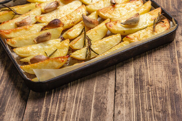 Baked pieces of spiced potato in a baking pan