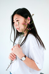 portrait of a girl of Asian appearance on a white background with spring flowers