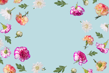Beautiful spring or summer layout with different flying flowers and leaves on pastel blue background, trendy floral frame