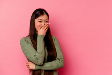 Young chinese woman isolated on pink background laughing happy, carefree, natural emotion.