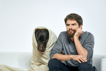 Man at home on the couch with a dog friendship fun