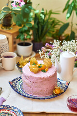 Pumpkin sponge cake with berry cream, decorated with physalis. Side view. 