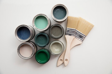 Overhead view of a DIY paint brush with trendy green sample paint pots