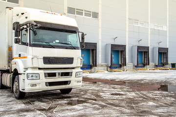 Truck while loading in a big distribution warehouse with gates for for loading goods and trucks