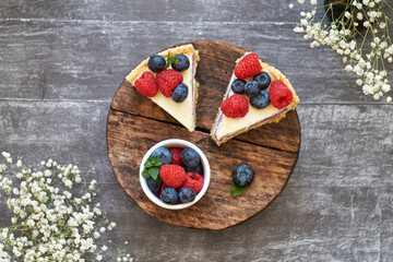 Cheesecake with berries on a grey wooden background. Top view.