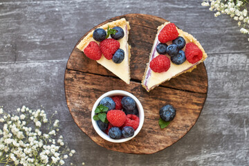 Cheesecake with berries on a grey wooden background. Top view.