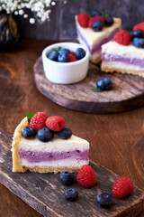 Cheesecake with berries on a wooden background. Side view.