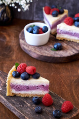 Cheesecake with berries on a wooden background. Side view.