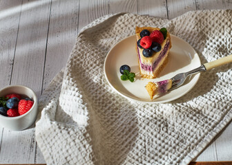 Cheesecake with berries on a white background. Side view.