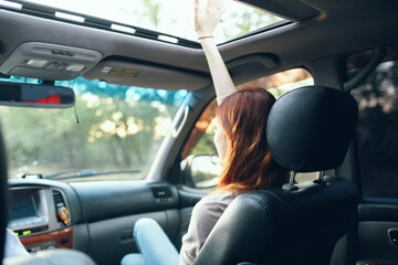 woman with an open window in the front seat of a car gesturing with her hands interior salon fellow traveler