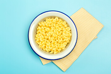 Pasta background. Mac and Cheese pasta on a blue background. American style Italian pasta with cheese.