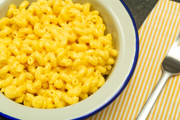 Pasta background. Mac and Cheese pasta on a kitchen background. American style Italian pasta with cheese.