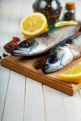 Raw mackerel on a cutting board with spices.