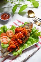 fried crispy fish with sweet and sour sauce in a plate