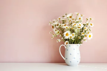 Rolgordijnen Front view of white daisy flowers in vase on table against empty pink blank wall with copy space for your advertisement, design, template or information. Interior, summer and decoration concept © shurkin_son