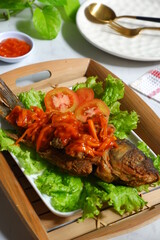 fried crispy fish with sweet and sour sauce in a plate