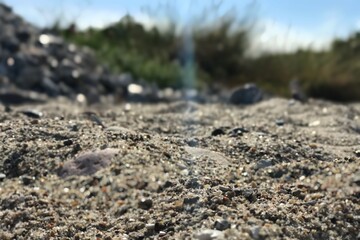 Closeup of blue sunray beam falling on grey grit sand 