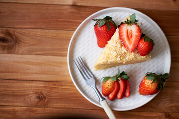 Napoleon cake with strawberries on a wooden background. Top view.