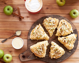 scones with apple, pistachios and white chocolate on a wooden background.