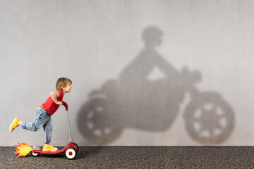 Happy kid dreams about bike. Imagination, freedom and motivation concept