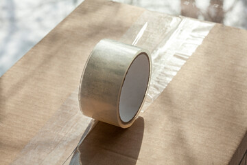 Adhesive tape lies on the carton box.  
close-up