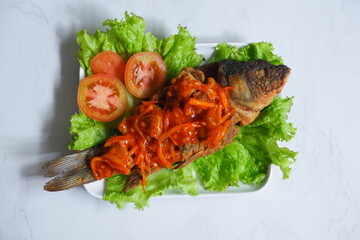 fried crispy fish with sweet and sour sauce in a plate